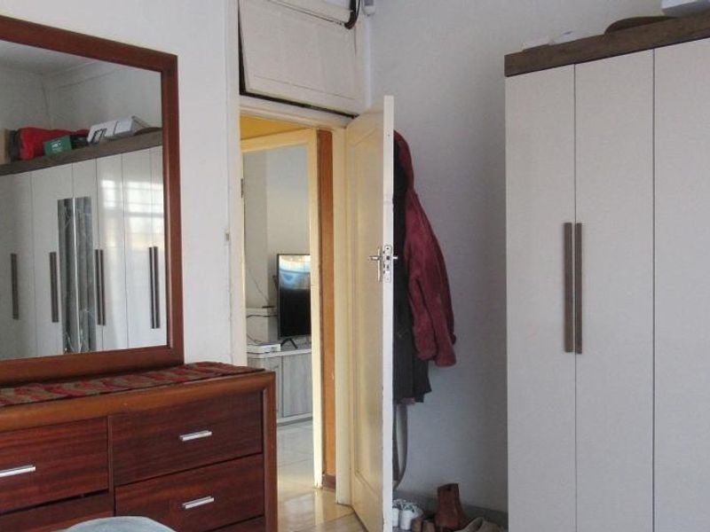 Bedroom featuring built-in cabinetry with a mirrored door, showing signs of wear including a cracked mirror panel.