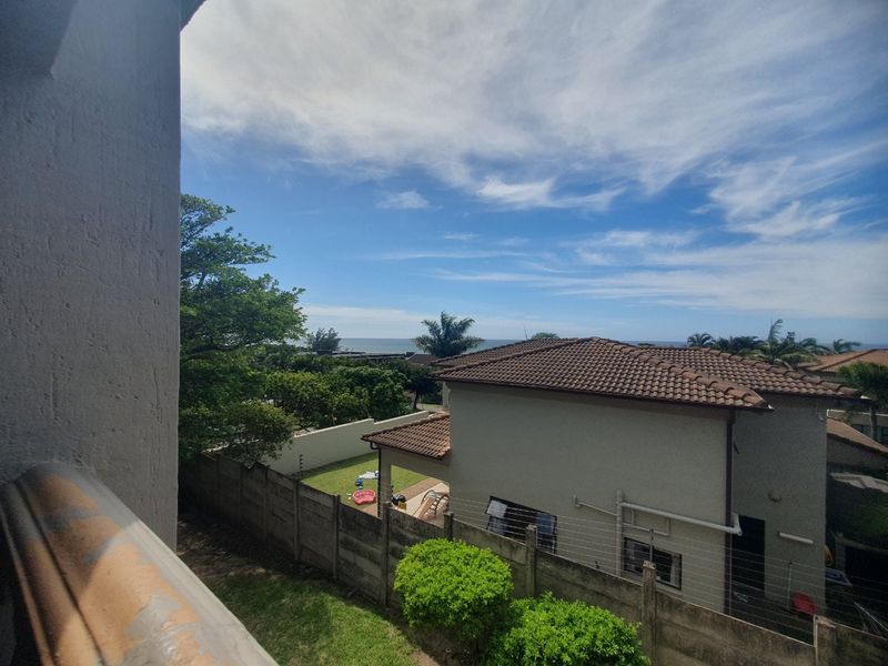 Elevated view overlooking the surrounding residential area and garden, featuring a clear perspective of the neighborhood and distant horizon.