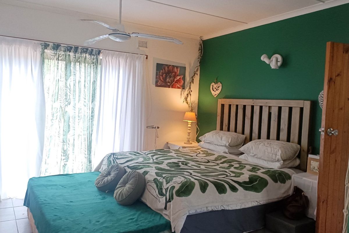A bedroom featuring tiled flooring, a ceiling fan, and a sliding glass door providing access to the exterior.