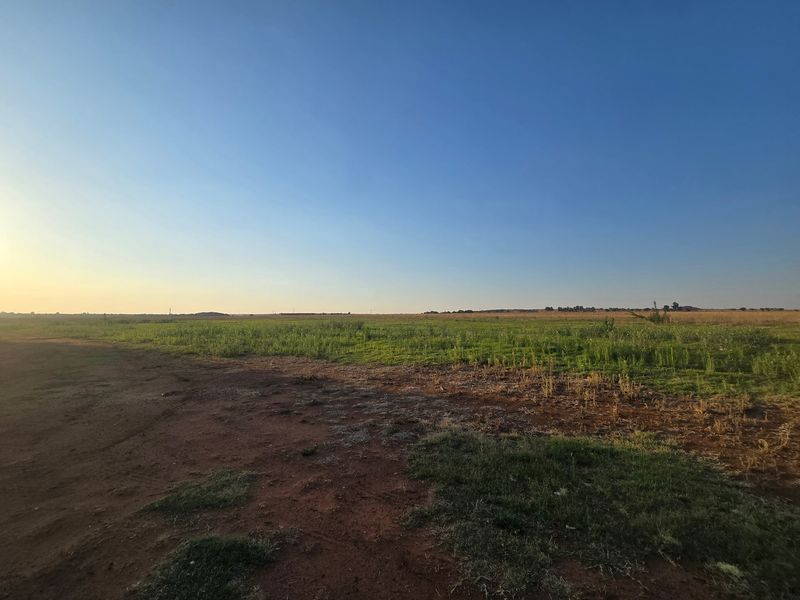 A wide-angle view of the expansive open pasture and natural landscape on the farm property.