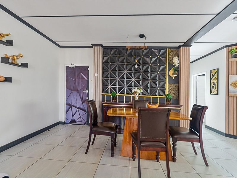 A dining area featuring modern geometric wall paneling, slatted wood accents, and neutral tiled flooring, creating a contemporary and structured living space.