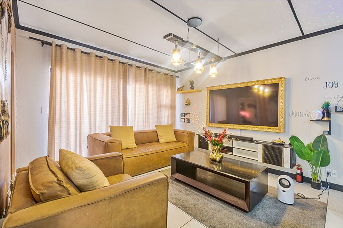 A well-lit living room featuring tiled flooring, a modern ceiling light fixture, and a sliding glass door providing access to the exterior.