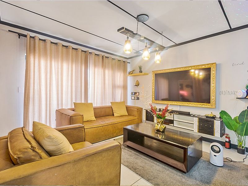 A well-lit living room featuring tiled flooring, a modern ceiling light fixture, and a sliding glass door providing access to the exterior.