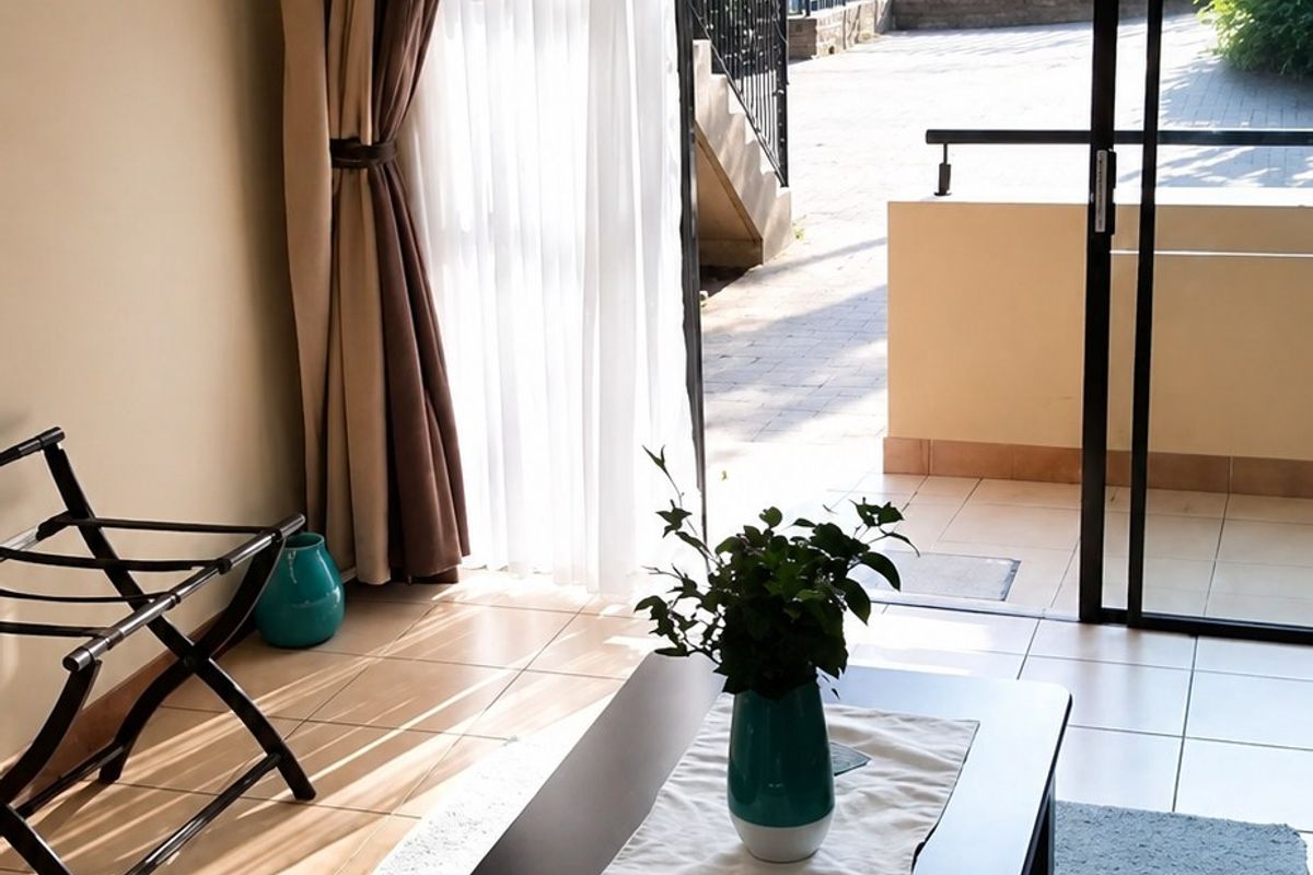 Living room featuring ceramic floor tiles and a large sliding glass door providing direct access to an outdoor patio area.