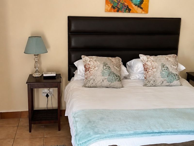 A bedroom featuring tiled flooring and neutral wall finishes, providing a functional space for rest.