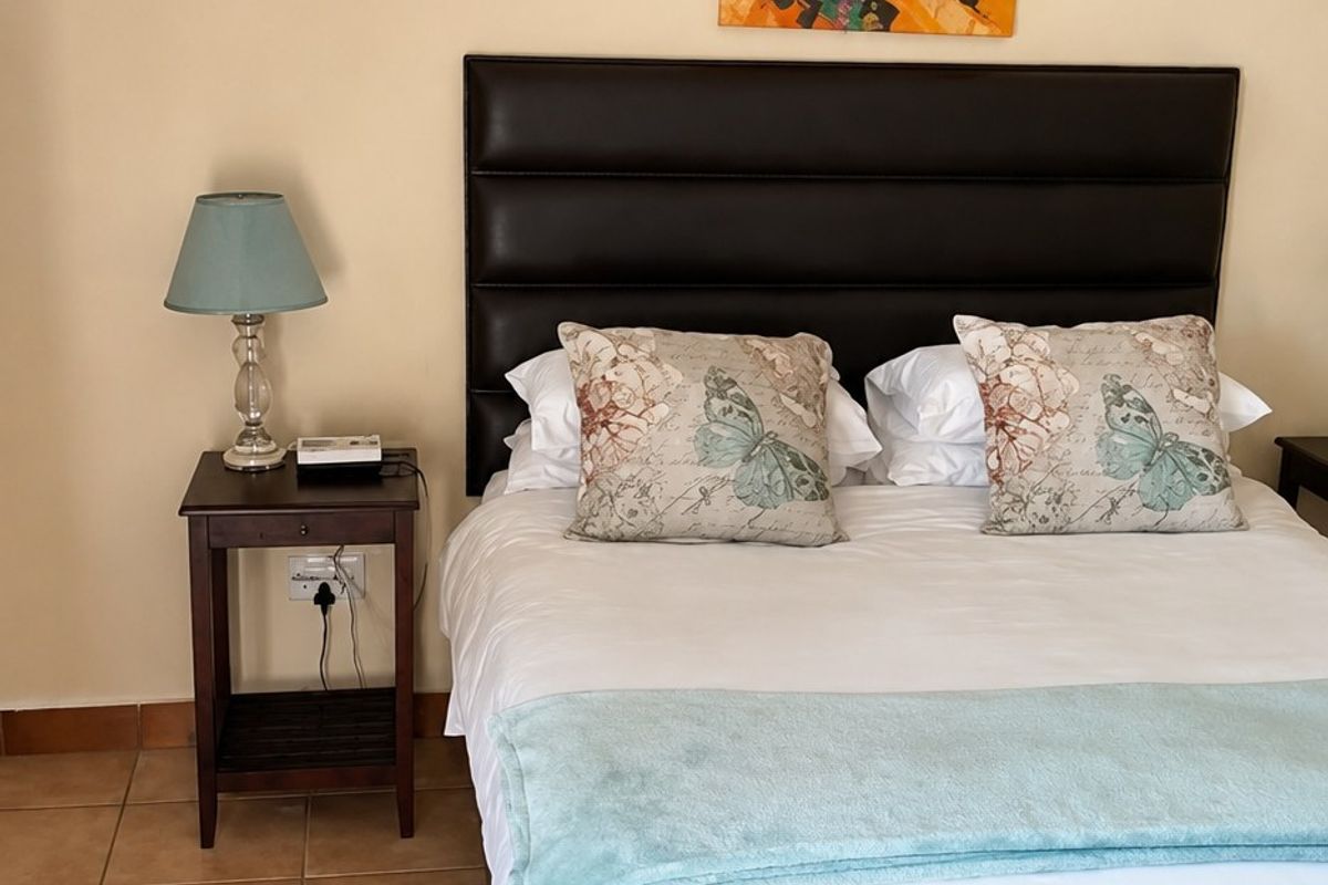 A bedroom featuring tiled flooring and neutral wall finishes, providing a functional space for rest.