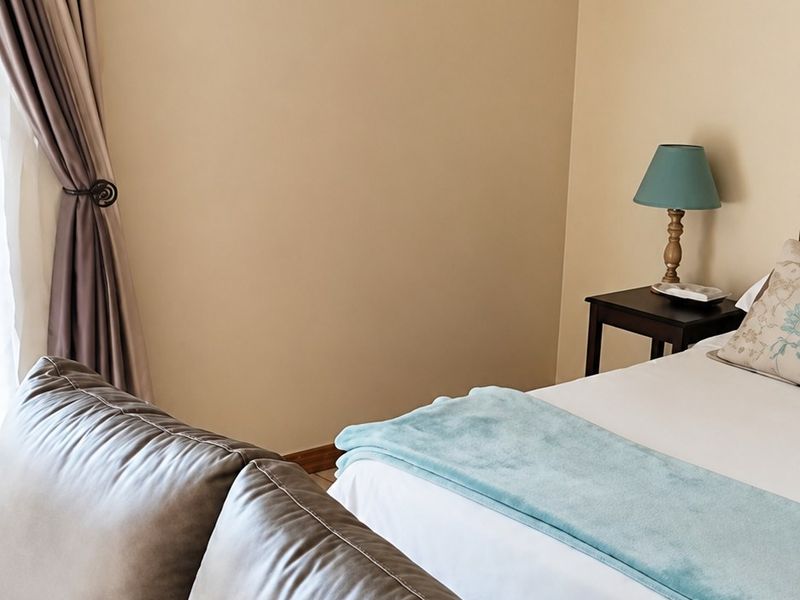 A bedroom featuring neutral wall tones, tiled flooring, and decorative coving, providing a comfortable and functional living space.