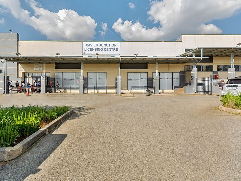 Front exterior view of the Xavier Junction Licensing Centre featuring a paved driveway, covered entrance walkway, and prominent building signage.