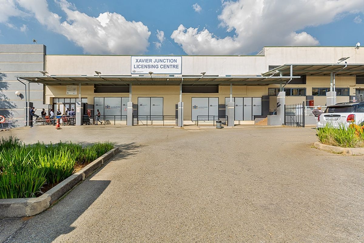 Front exterior view of the Xavier Junction Licensing Centre featuring a paved driveway, covered entrance walkway, and prominent building signage.