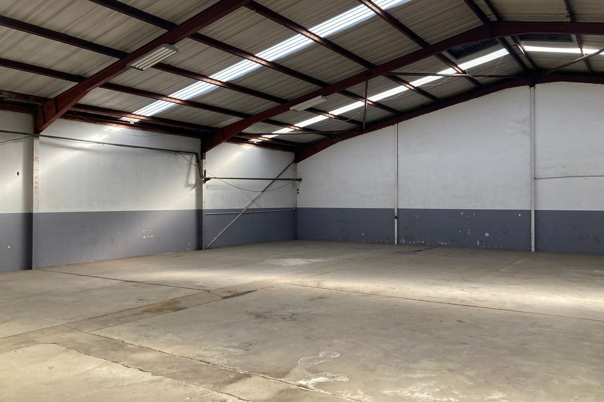 Spacious industrial warehouse unit featuring a high-clearance steel portal frame, concrete flooring, and natural light provided by integrated roof skylights.