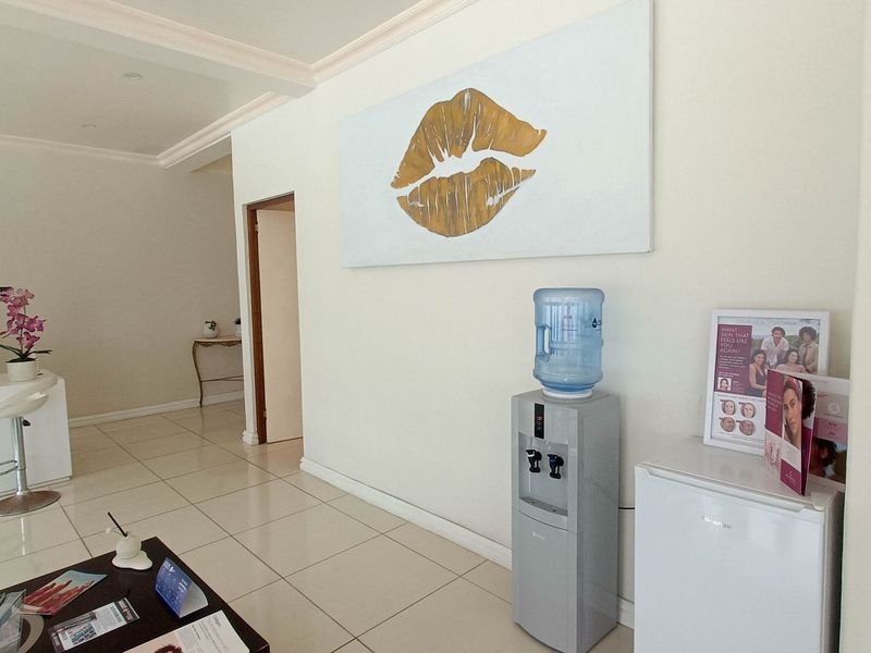 A bright and welcoming commercial reception area featuring clean tiled flooring, neutral walls, and decorative ceiling molding.