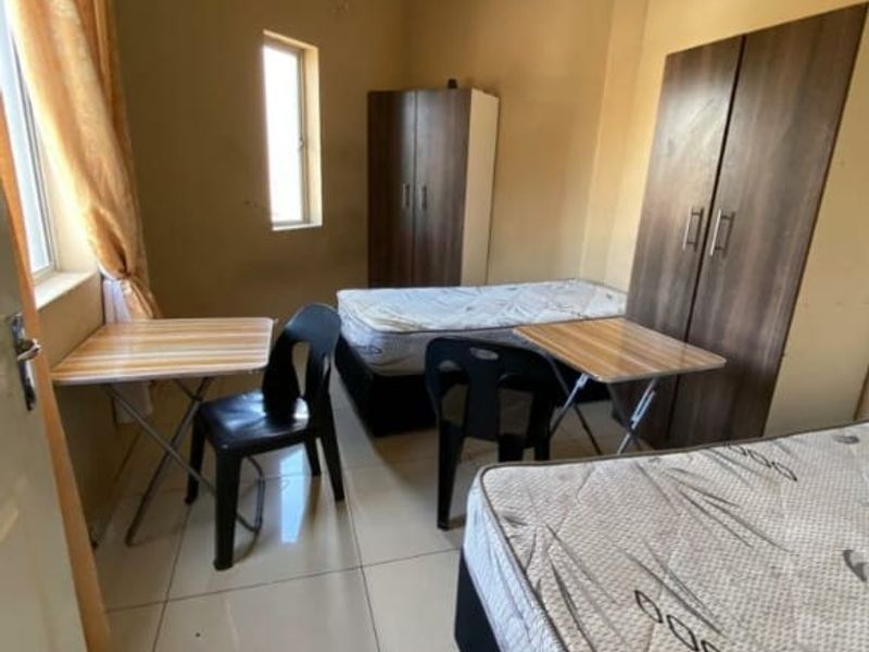 A functional bedroom space featuring tiled flooring and neutral wall finishes, suitable for residential or commercial accommodation use.