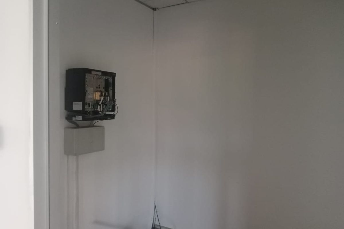 A small utility or server room featuring an exposed electrical distribution board and suspended ceiling, currently in a vacant, unfinished state.