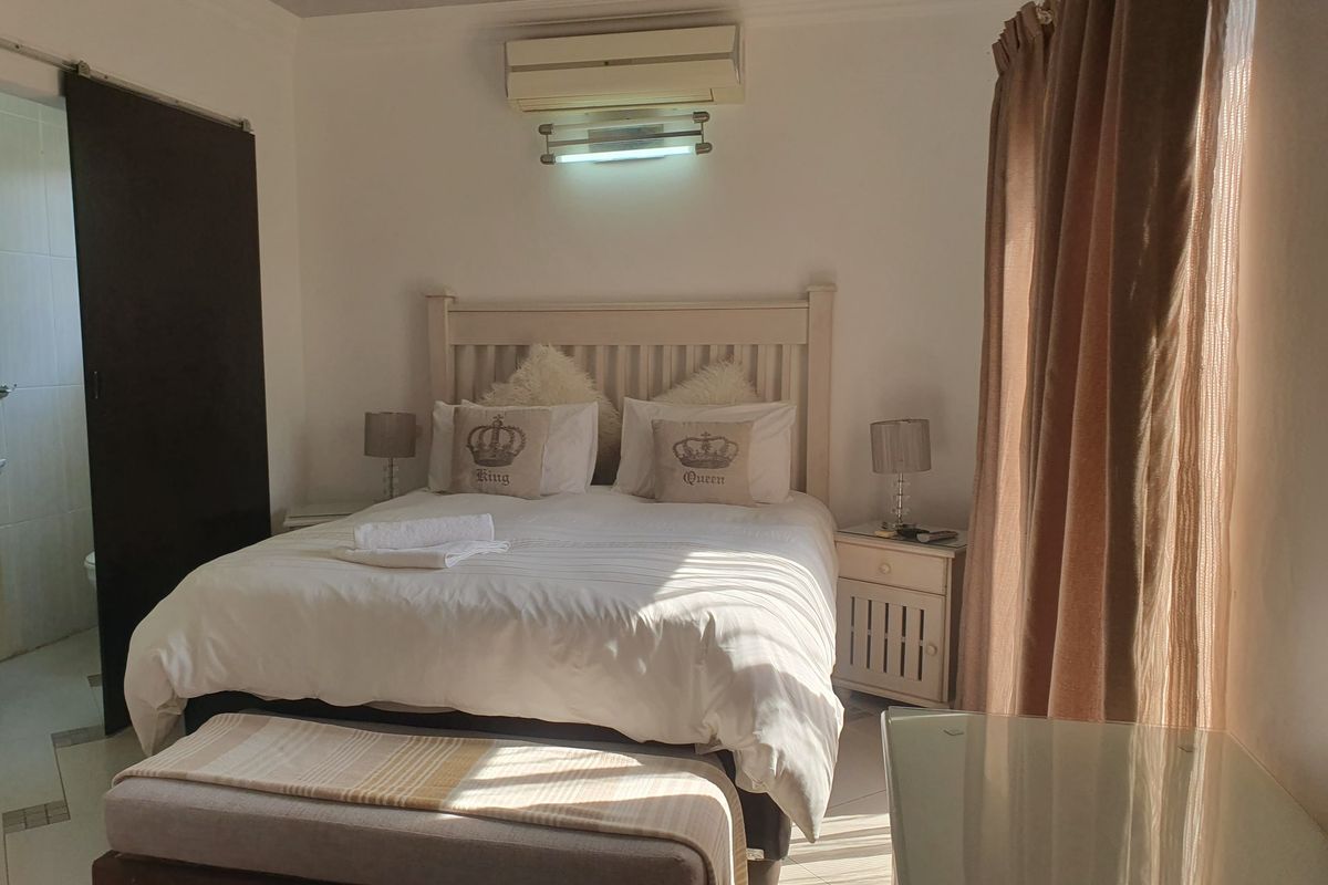 A bedroom featuring tiled flooring, an integrated air conditioning unit, and a sliding door providing access to an adjoining space.