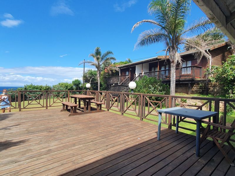 Spacious timber deck patio offering outdoor entertainment space with balustrades and views of the surrounding landscape and ocean.