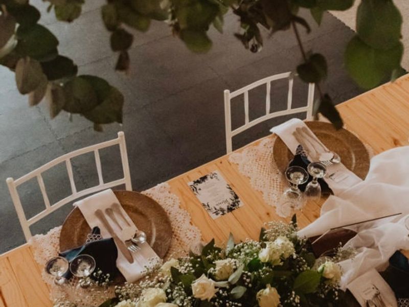 A high-angle view of a decorated dining table set for an event, featuring floral arrangements and place settings.