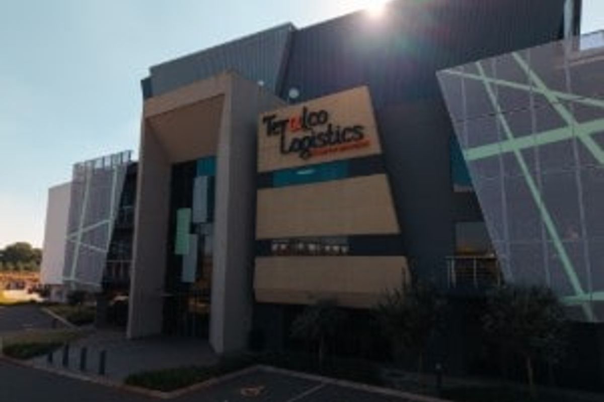 Modern industrial logistics facility featuring a contemporary facade with metal cladding, decorative architectural panels, and integrated glass elements.