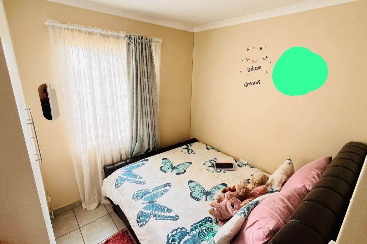 A compact bedroom featuring tiled flooring and a built-in cupboard, providing functional storage space.