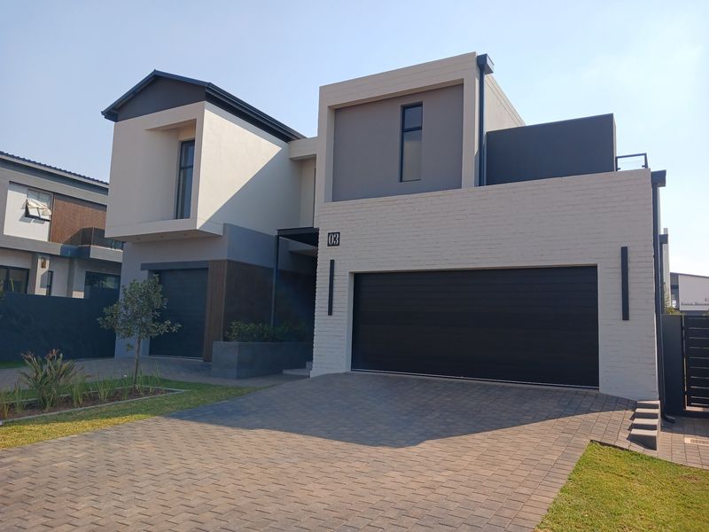 Modern double-story residential property featuring a contemporary brick facade, double garage, and a neatly paved driveway.