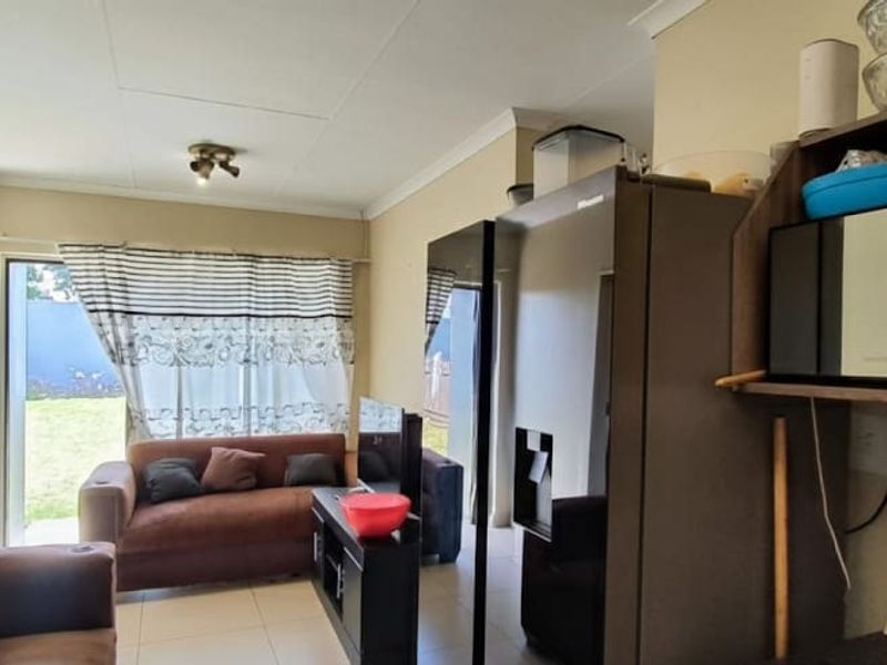 Open-plan living area featuring tiled floors and a sliding glass door providing direct access to the rear garden.