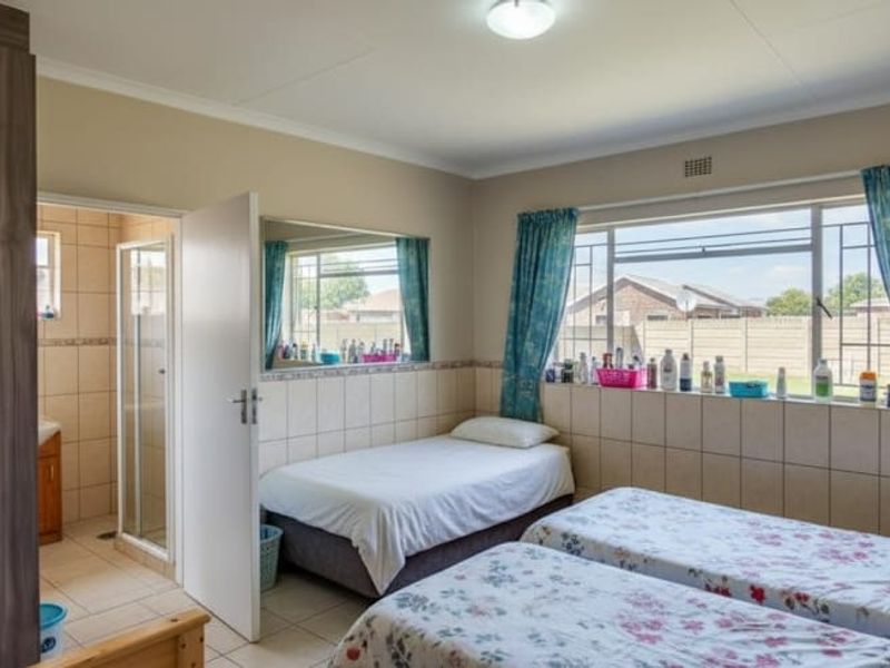 A bedroom featuring tiled walls, a built-in wardrobe, and an attached en-suite bathroom with a shower.