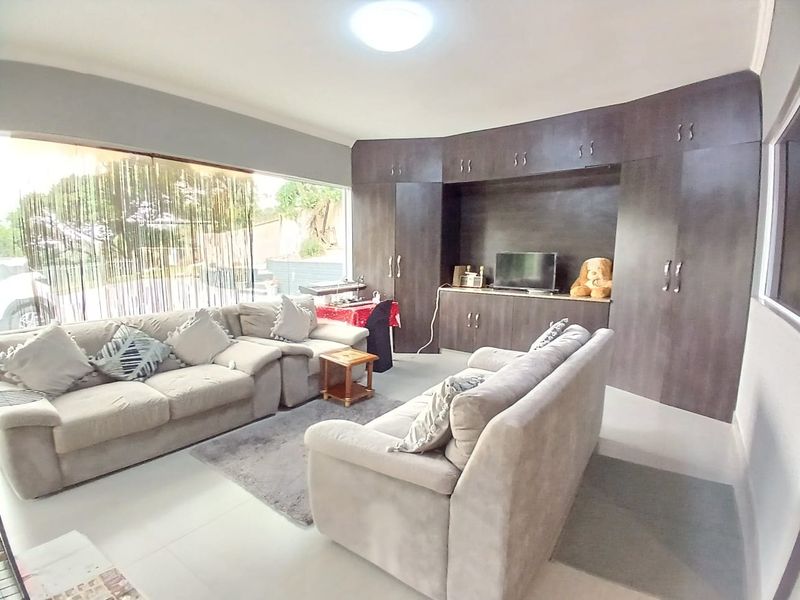 Spacious living room featuring large windows for natural light and extensive built-in cabinetry for storage.