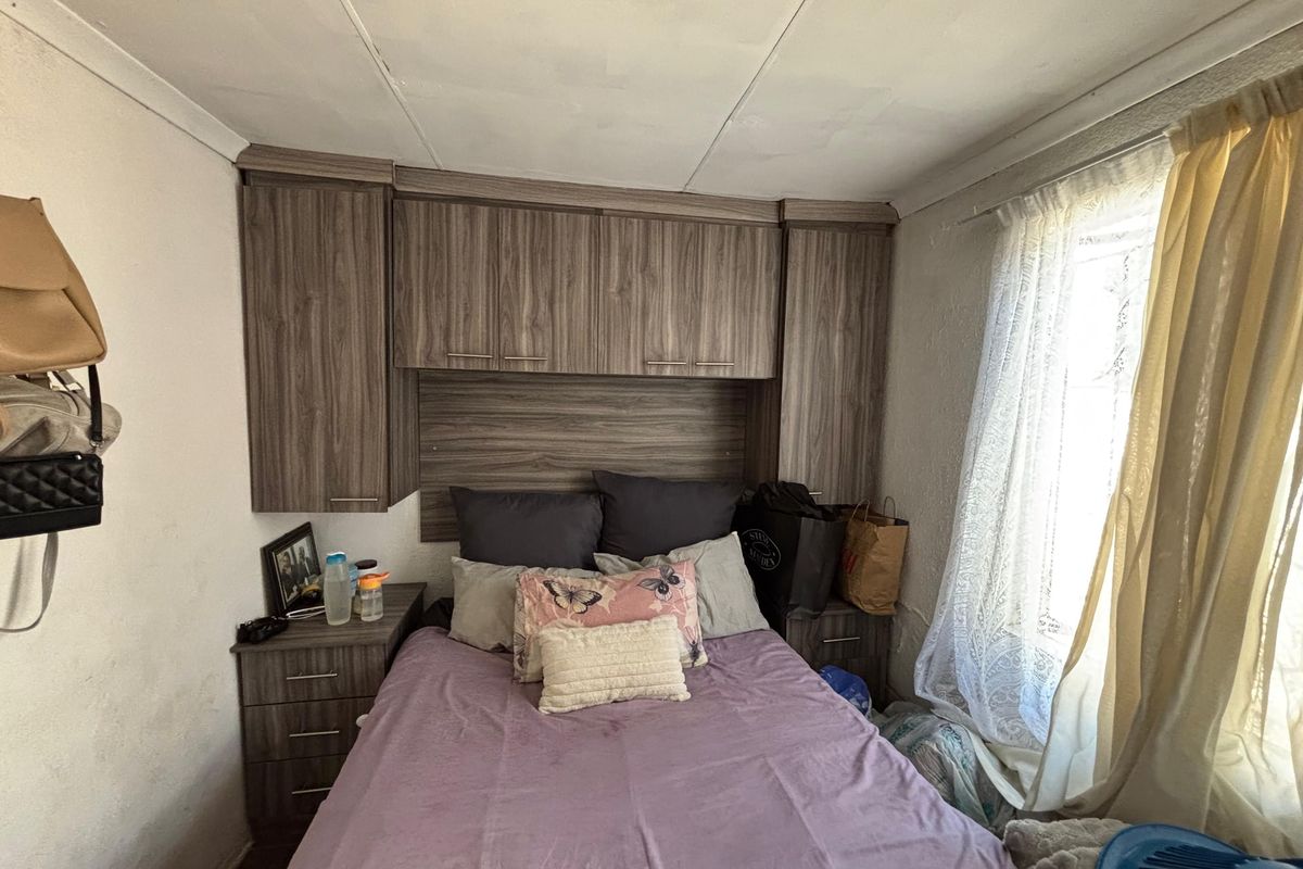 A bedroom featuring built-in wood-grain cabinetry surrounding the bed area, providing integrated storage and bedside shelving.