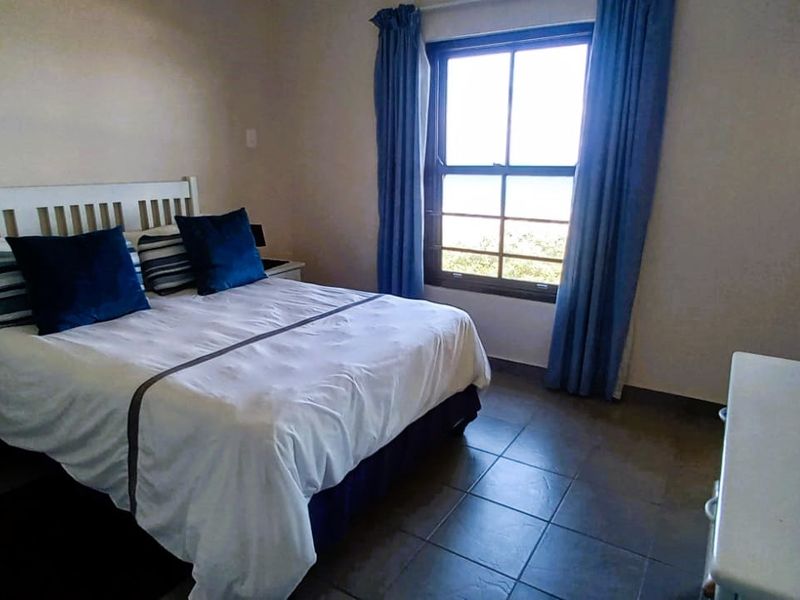 A functional bedroom featuring tiled flooring and a window with natural light, providing a comfortable space for rest.