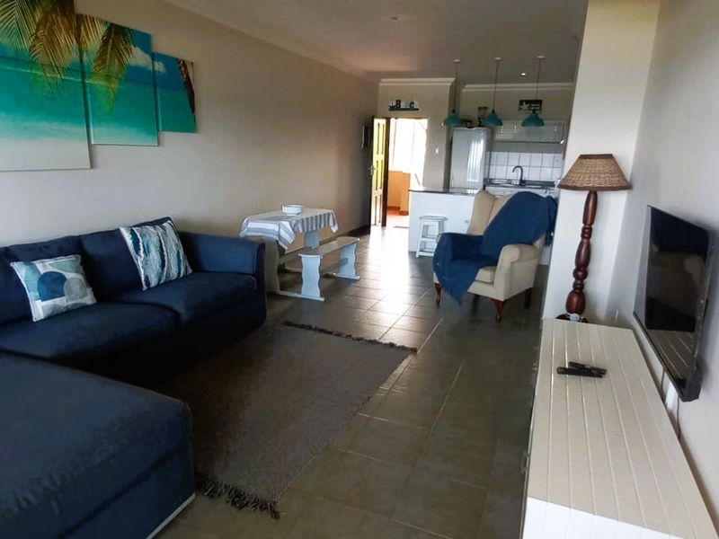 Open-plan living area featuring tiled flooring and a connected kitchen space, providing a functional layout for modern apartment living.