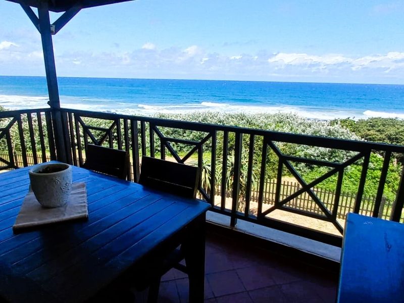 A covered balcony featuring a metal railing and direct, unobstructed views of the ocean and coastline.