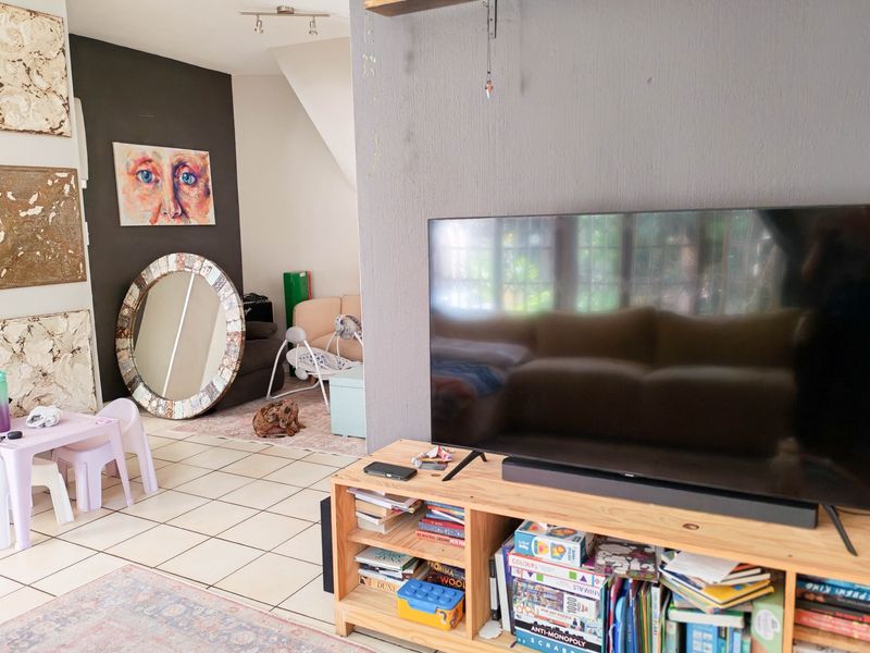 A living room area featuring tiled flooring and neutral wall finishes, providing a functional space for relaxation and entertainment.