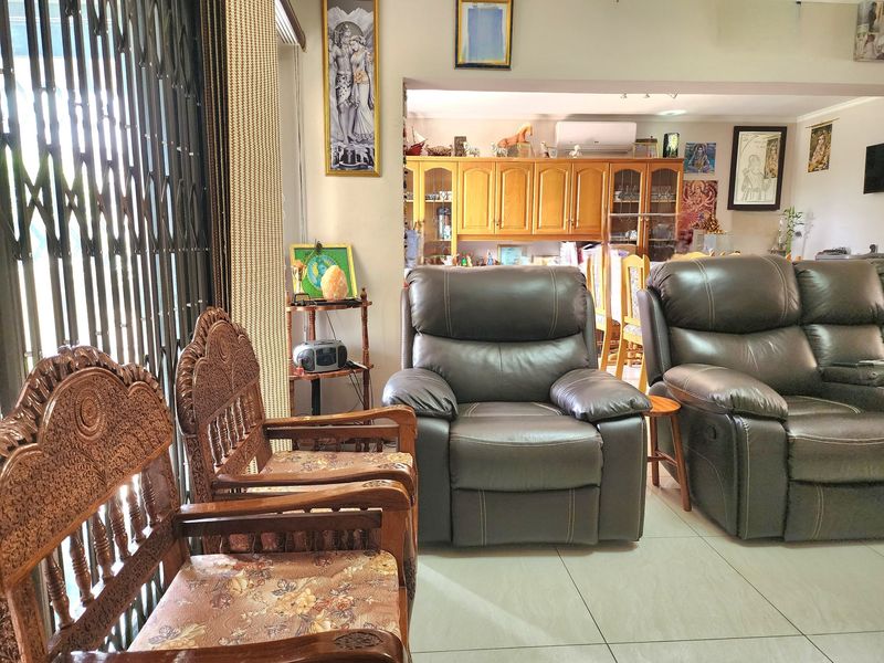 Open plan living area featuring tiled flooring, built-in cabinetry, and an air conditioning unit, connecting the lounge and dining spaces.