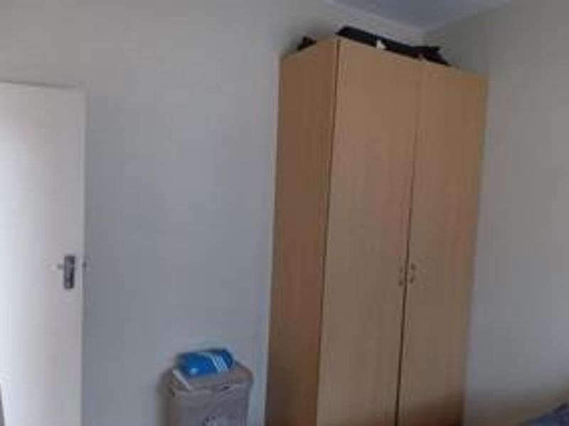 A bedroom featuring a built-in wardrobe and neutral wall finishes.