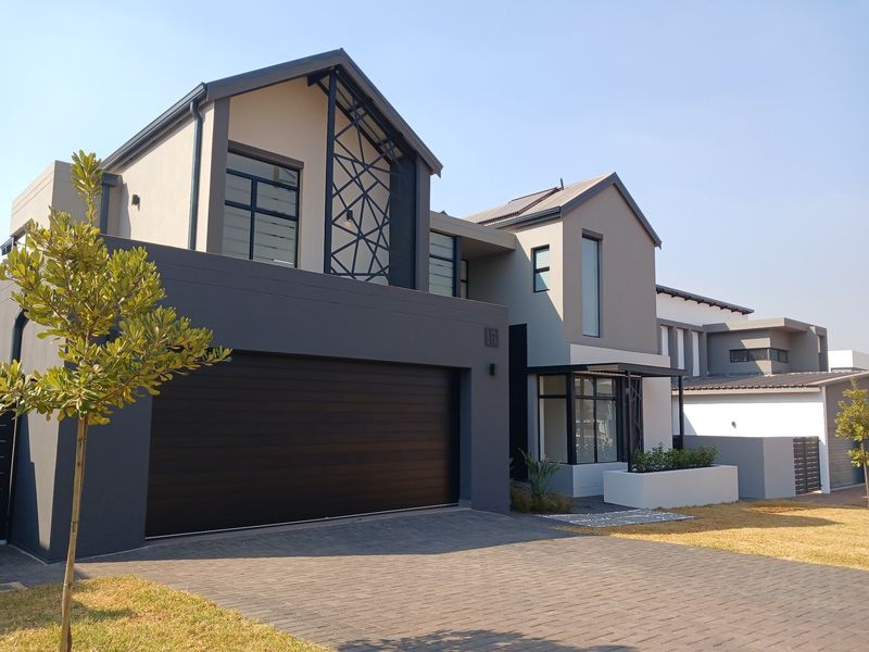 Modern double-story residential home featuring a contemporary facade, paved driveway, and integrated double garage.