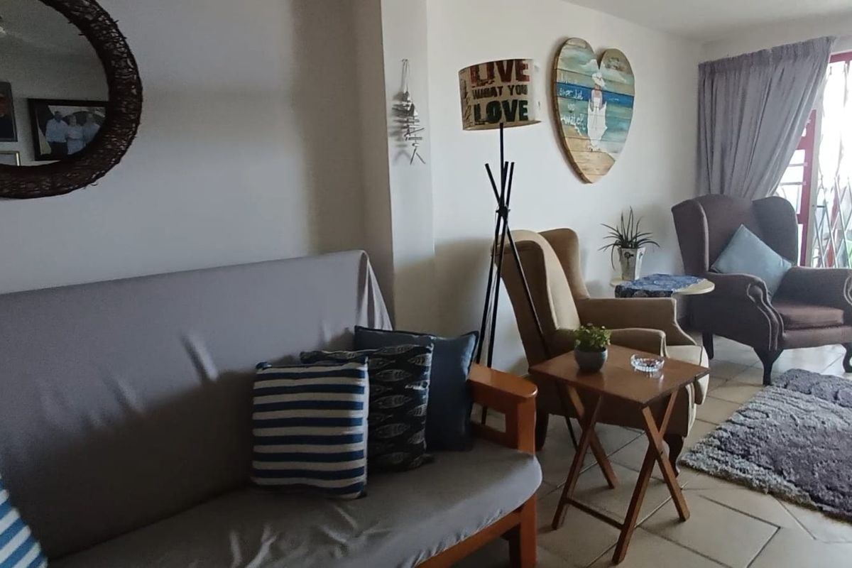 A comfortable living room area featuring tiled flooring and access to an outdoor space through a secure metal gate.