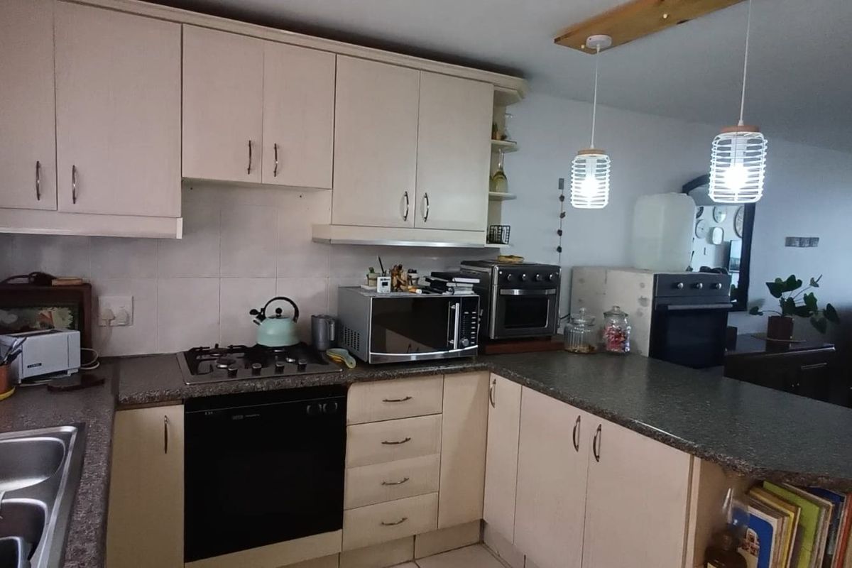 A functional kitchen featuring built-in cabinetry, a gas hob, integrated oven, and laminate countertops, offering a practical layout for daily cooking and meal preparation.