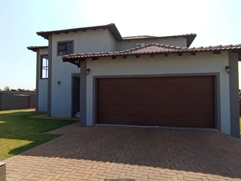 A modern double-story residential home featuring a paved driveway, a spacious double garage, and a well-maintained exterior facade.