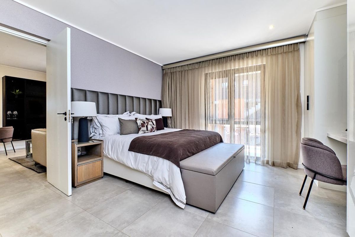 Modern bedroom featuring tiled flooring, recessed lighting, a built-in headboard, and a sliding glass door providing access to an outdoor area.
