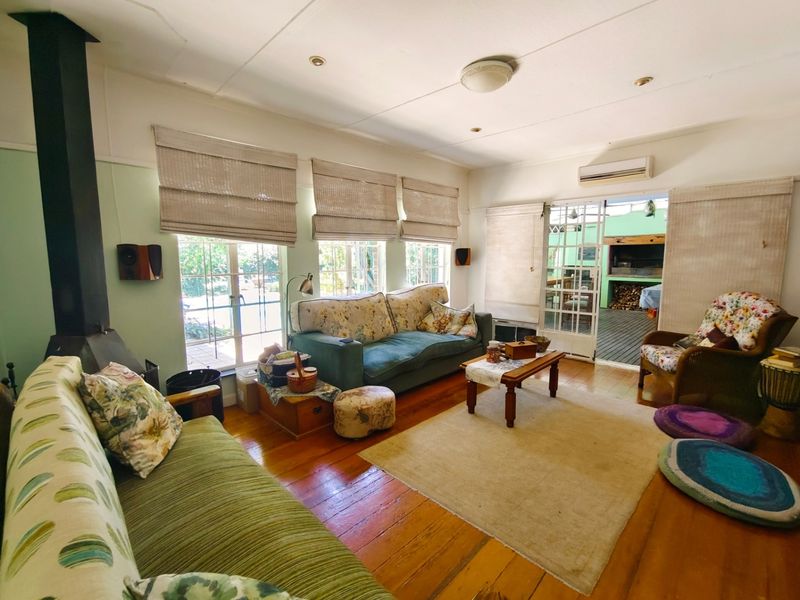 A cozy living room featuring polished hardwood floors, a freestanding fireplace, and direct access to an outdoor patio area through glass french doors.