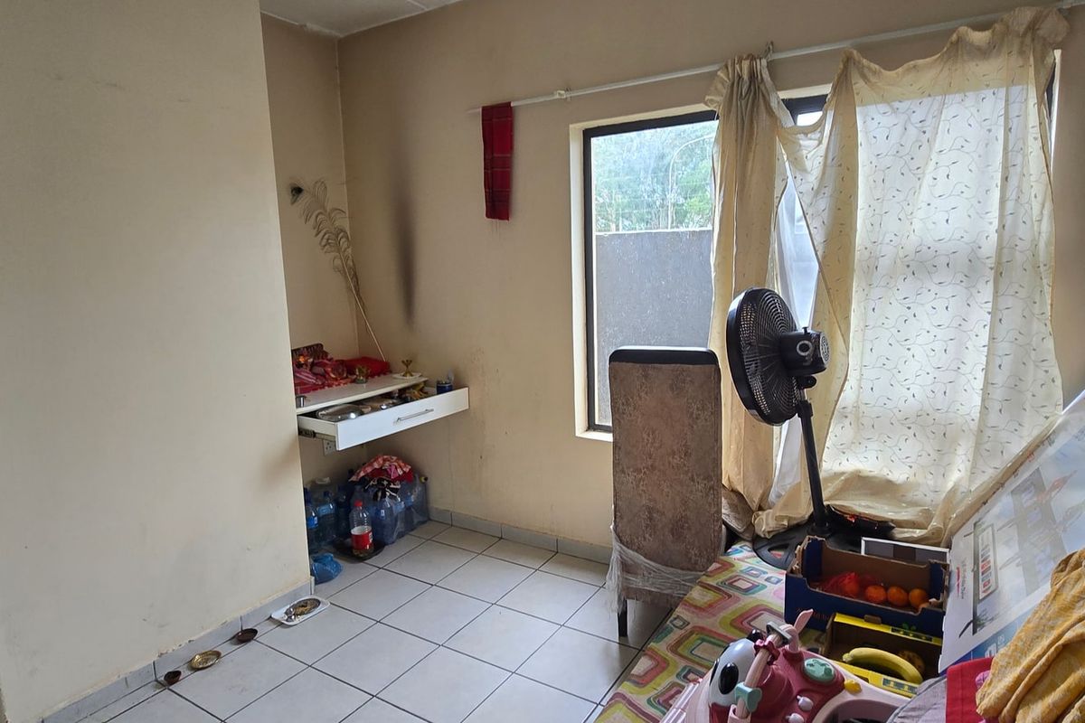 A bedroom featuring tiled flooring and a wall-mounted shelf, currently showing signs of wear and requiring cosmetic updates to improve its overall condition.