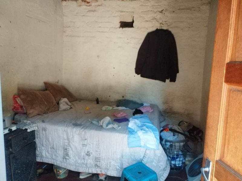 A small bedroom featuring exposed brick walls requiring significant plastering and finishing work to improve the overall condition and aesthetic appeal.