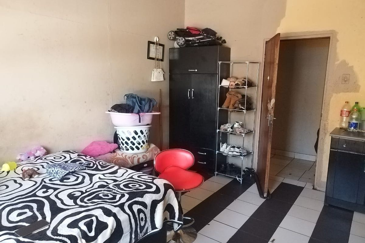 A bedroom featuring tiled flooring and an internal door, currently requiring wall repairs and fresh paint to improve the overall condition.