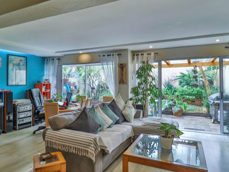 Spacious living room featuring laminate flooring, recessed lighting, and large sliding glass doors that provide seamless access to the outdoor patio area.