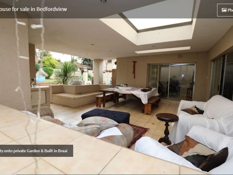 Covered patio area featuring built-in braai, tiled flooring, and skylights, providing direct access to the private garden.
