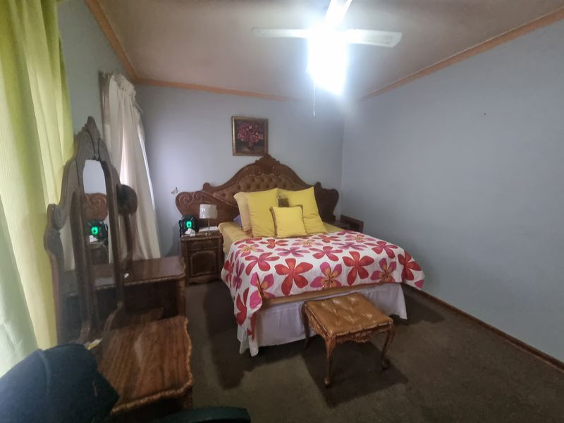 A bedroom featuring a ceiling fan and carpeted flooring.