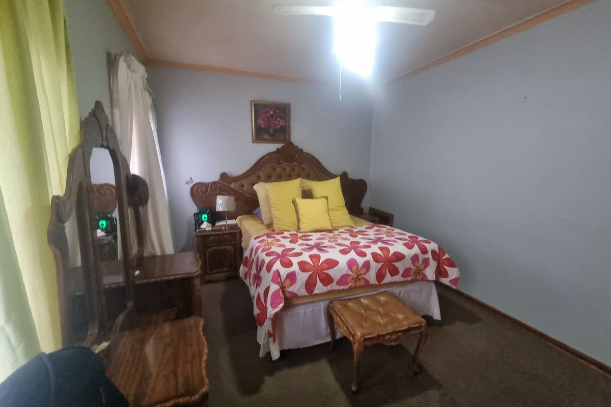 A bedroom featuring a ceiling fan and carpeted flooring.