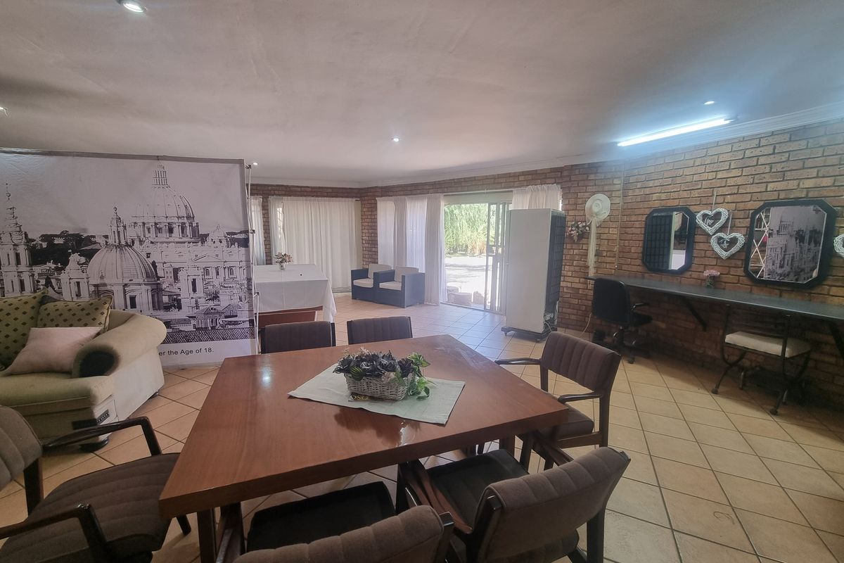 Spacious living area featuring exposed brick walls, ceramic tile flooring, and direct access to the outdoor area through a sliding glass door.