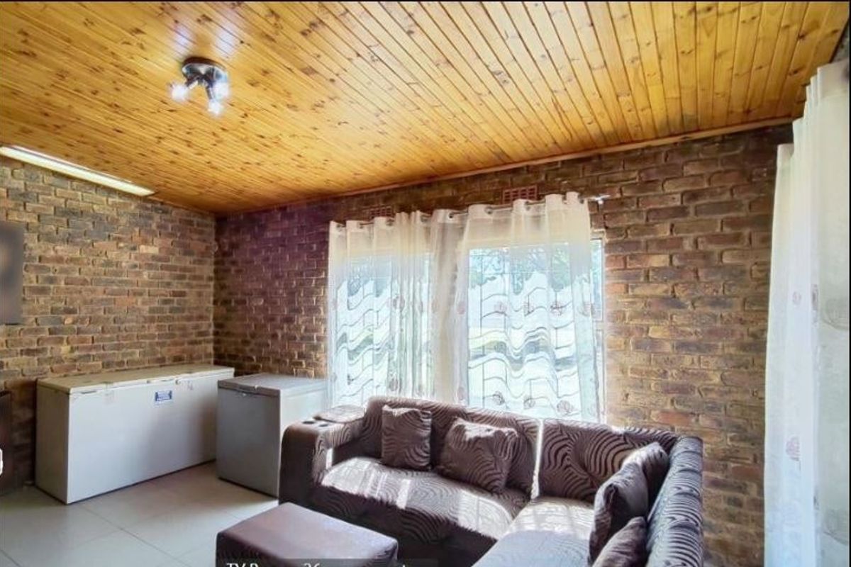 Living room featuring exposed brick walls, a timber tongue and groove ceiling, and tiled flooring.