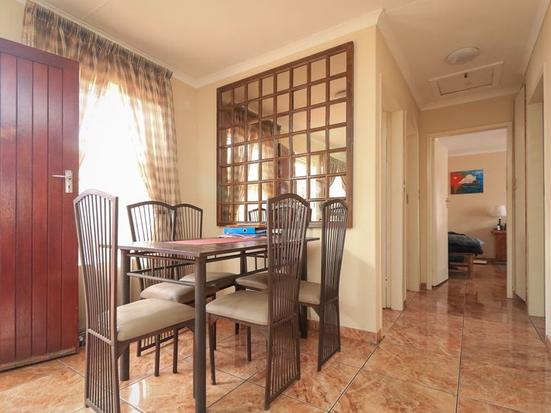 Dining area featuring tiled flooring and coved cornicing, providing a functional space with direct access to the hallway and adjacent rooms.