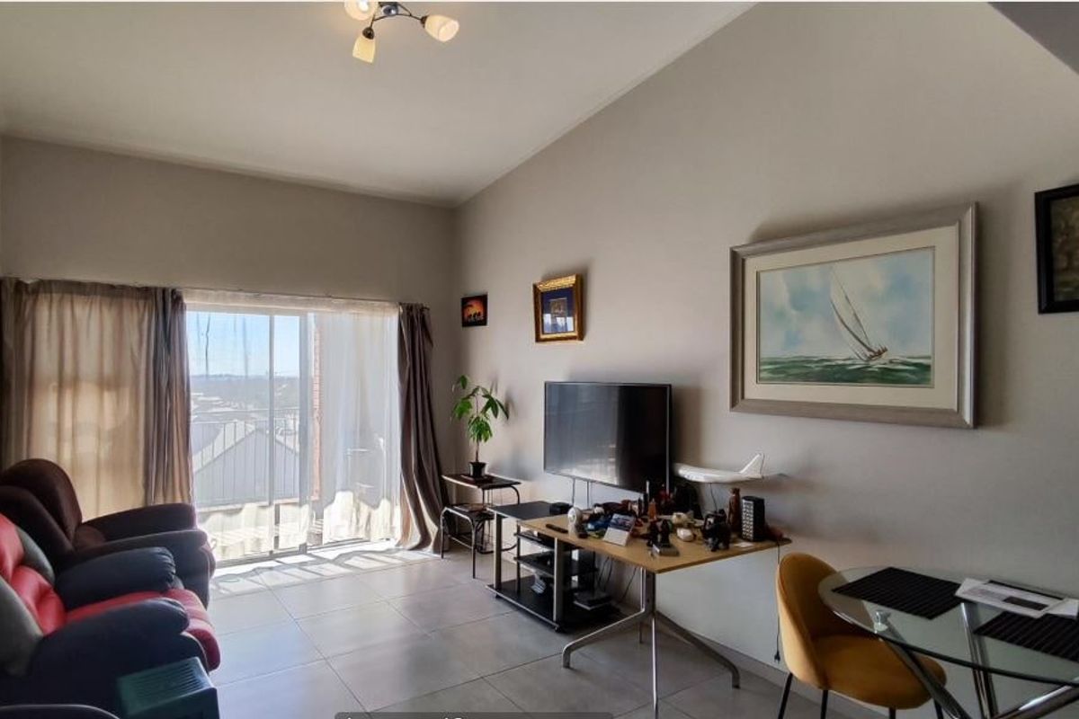 A living room featuring tiled flooring and a large sliding glass door that provides natural light and access to the exterior.